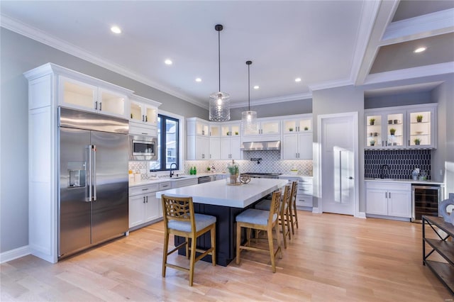 kitchen featuring sink, white cabinetry, built in appliances, wine cooler, and a kitchen island