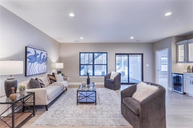 living room with wine cooler, hardwood / wood-style floors, and bar area