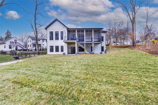 back of property with a sunroom, a yard, and a deck