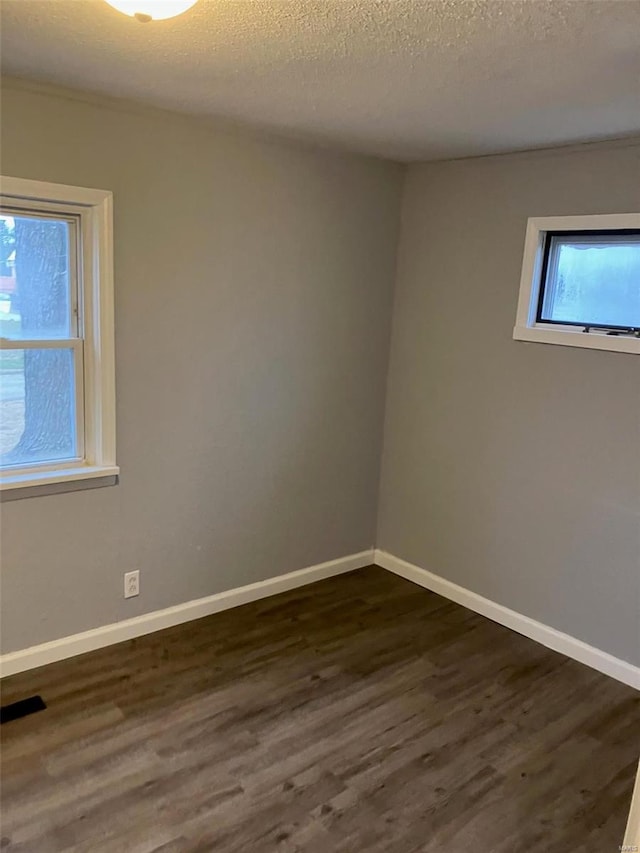 empty room featuring dark hardwood / wood-style flooring and a textured ceiling