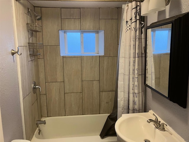 bathroom featuring shower / tub combo with curtain and sink