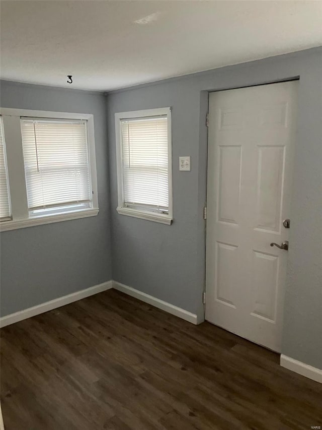 unfurnished room with dark wood-type flooring