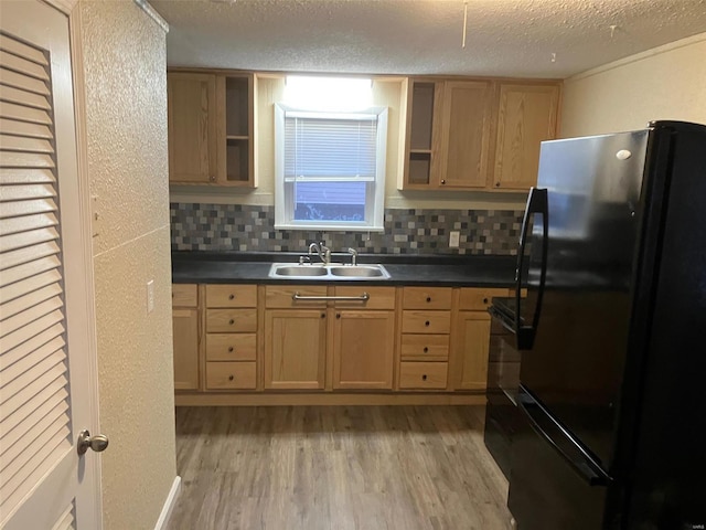 kitchen with sink, tasteful backsplash, a textured ceiling, light hardwood / wood-style floors, and black appliances