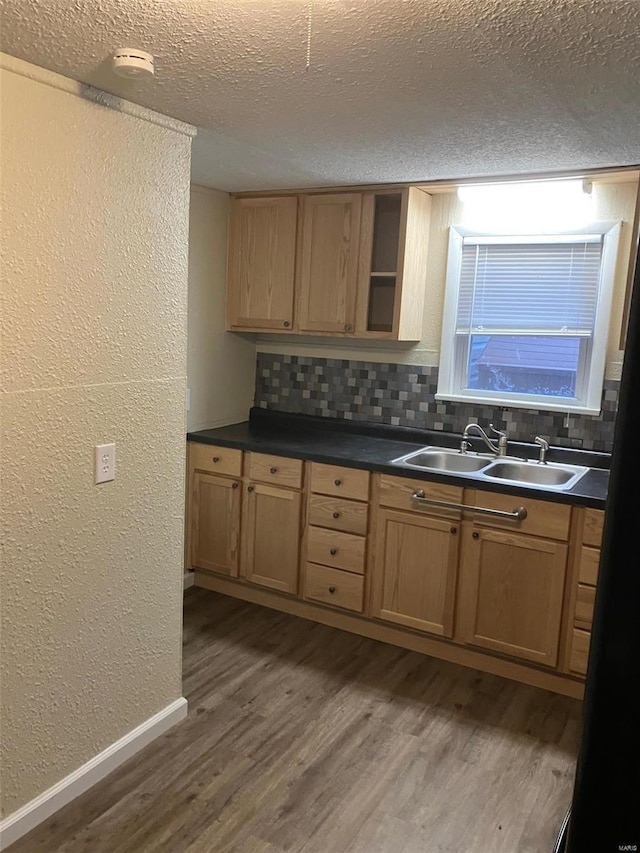 kitchen with sink, decorative backsplash, dark hardwood / wood-style floors, and a textured ceiling