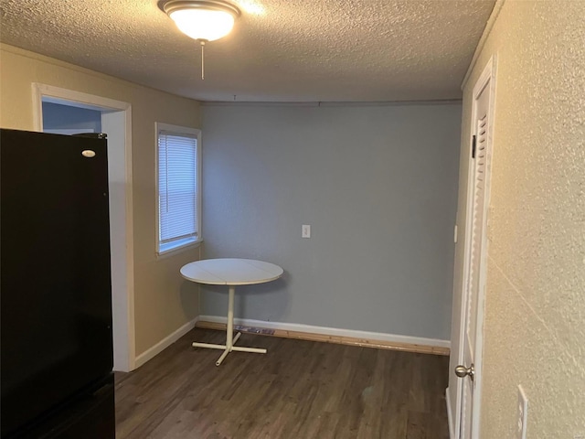 empty room featuring dark wood-type flooring and a textured ceiling