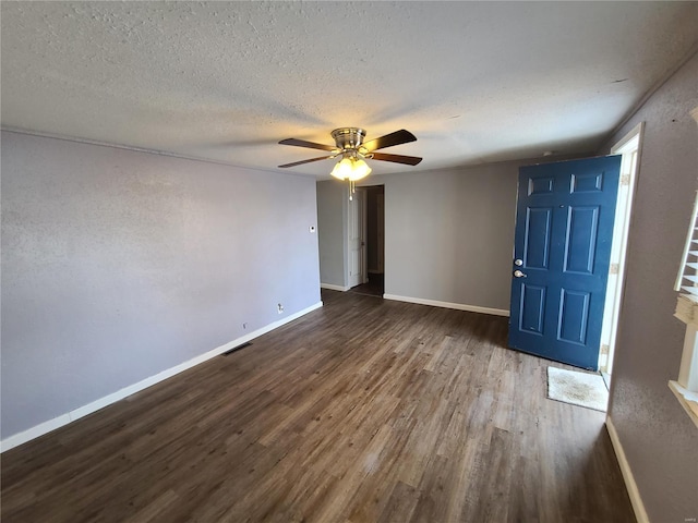 foyer entrance with ceiling fan, dark hardwood / wood-style floors, and a textured ceiling