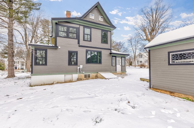 view of snow covered back of property