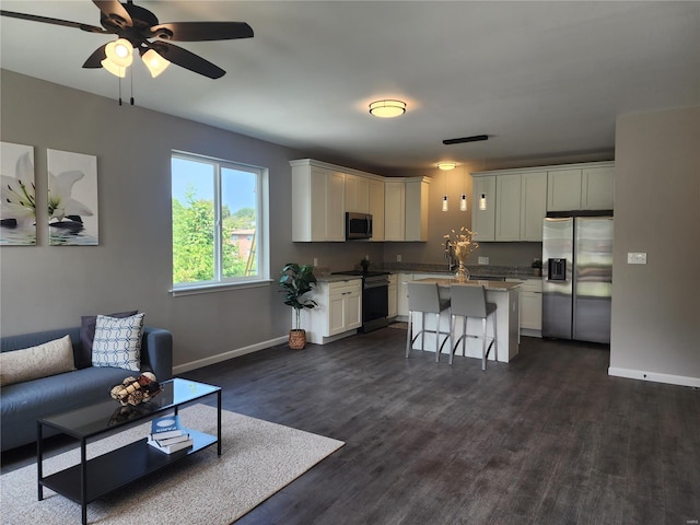 living room with ceiling fan and dark hardwood / wood-style floors