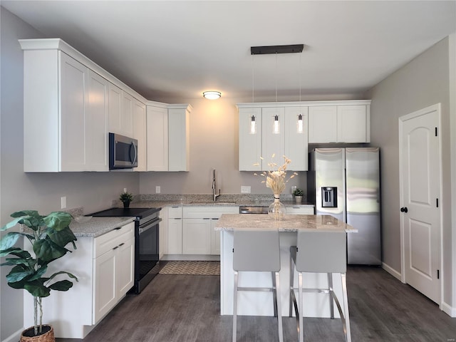 kitchen with stainless steel appliances, white cabinets, hanging light fixtures, and sink