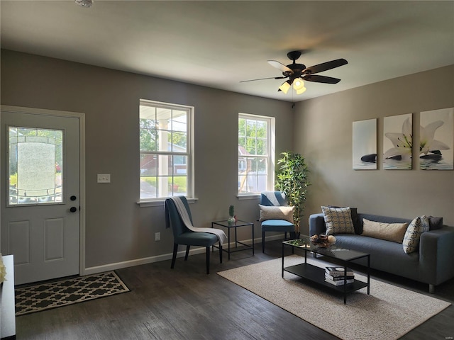 living room featuring dark wood-type flooring and ceiling fan