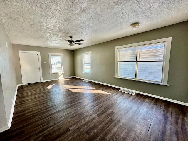 spare room featuring a textured ceiling, ceiling fan, and dark hardwood / wood-style flooring