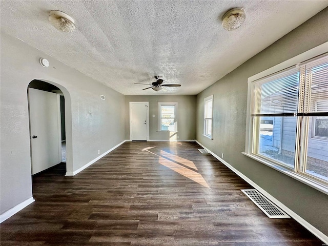 unfurnished room featuring a textured ceiling, ceiling fan, and dark hardwood / wood-style flooring