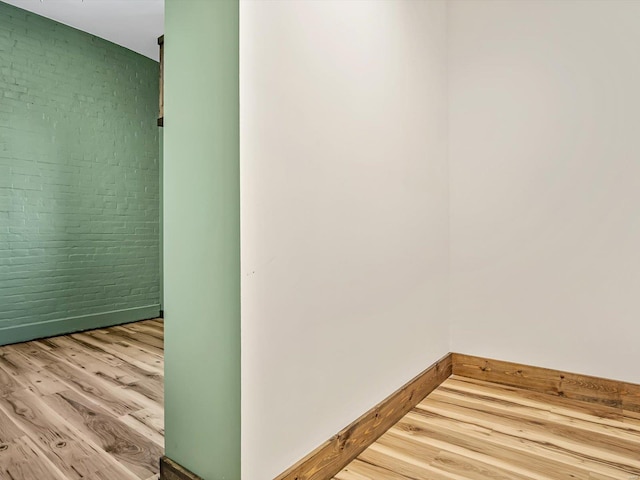 interior space featuring light hardwood / wood-style floors and brick wall