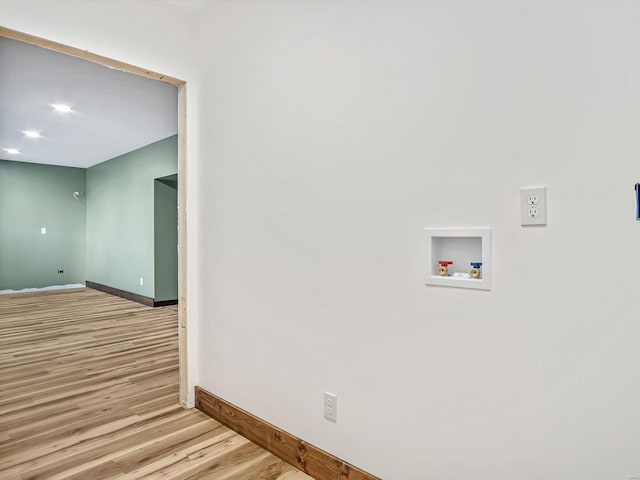 clothes washing area featuring washer hookup and light wood-type flooring