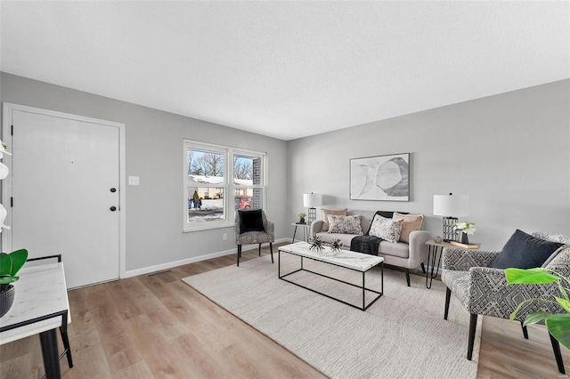 living room with a textured ceiling and light hardwood / wood-style floors