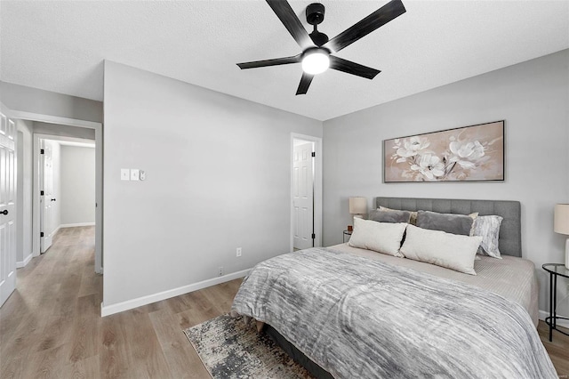 bedroom featuring ceiling fan, a textured ceiling, and light hardwood / wood-style flooring