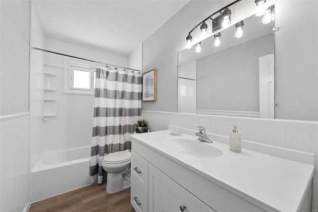 full bathroom with toilet, vanity, hardwood / wood-style flooring, a textured ceiling, and shower / bath combo with shower curtain