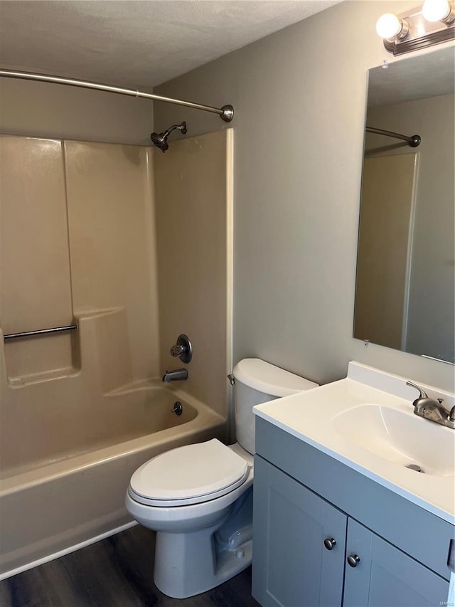 full bathroom featuring vanity, hardwood / wood-style floors, toilet, and washtub / shower combination