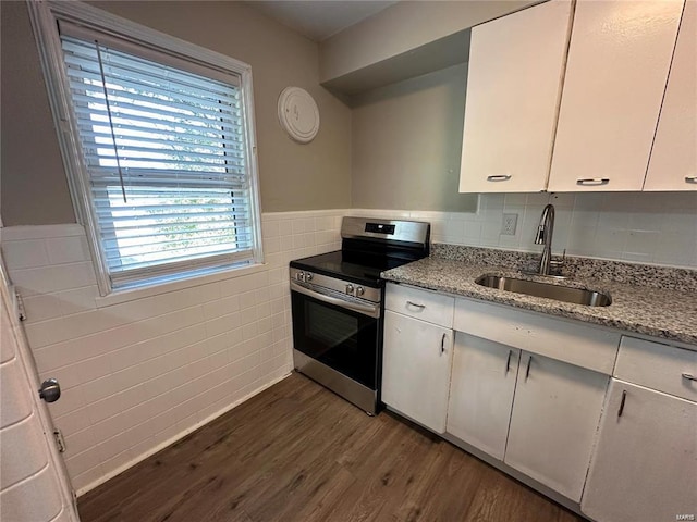 kitchen with sink, light stone countertops, stainless steel range with electric cooktop, and white cabinetry