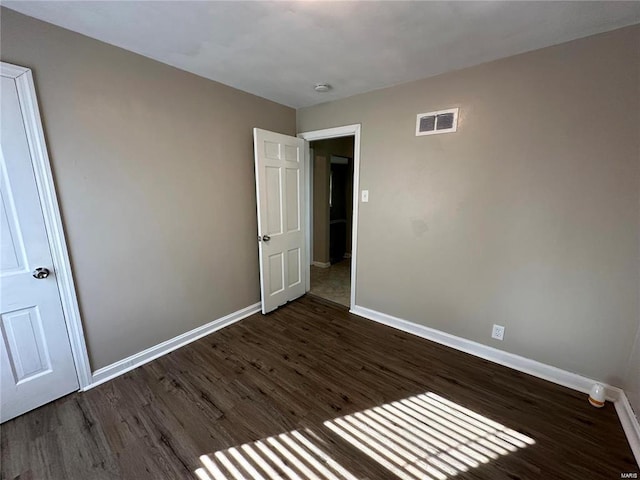 unfurnished bedroom with dark wood-type flooring