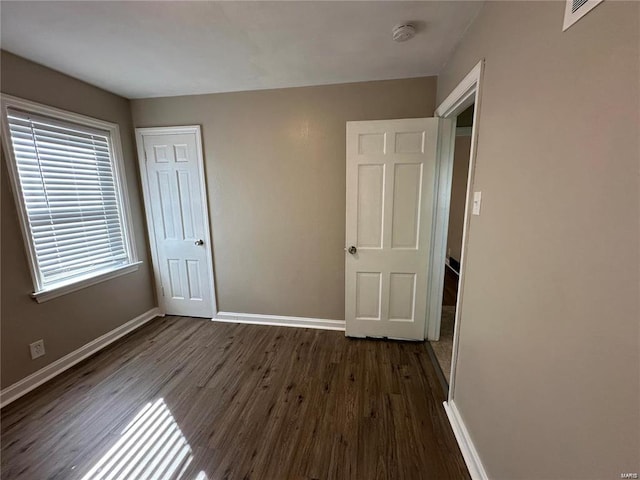 unfurnished bedroom with dark hardwood / wood-style flooring