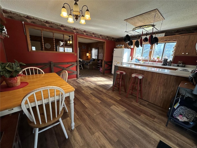 kitchen featuring a textured ceiling, white refrigerator, a chandelier, and hanging light fixtures