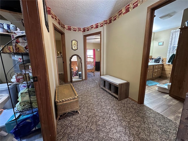 corridor with hardwood / wood-style flooring and a textured ceiling