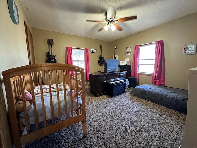 carpeted bedroom featuring a textured ceiling and ceiling fan