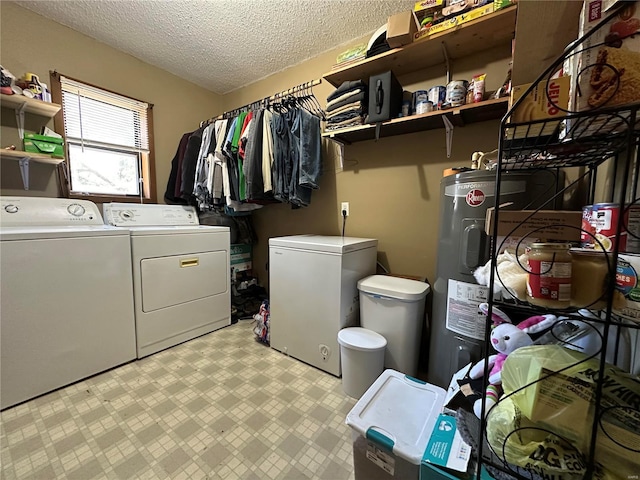 washroom featuring a textured ceiling, electric water heater, and washing machine and clothes dryer