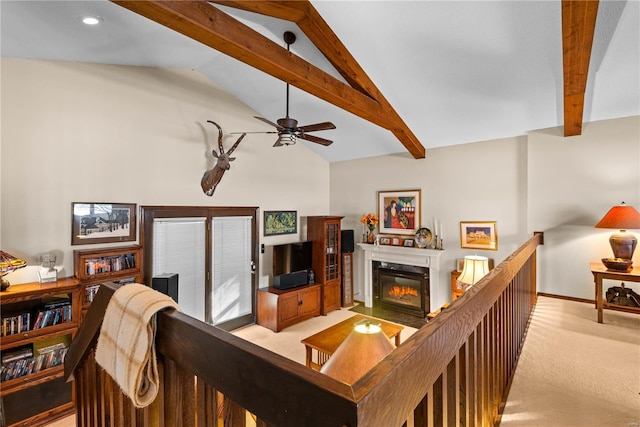 carpeted living room with ceiling fan and lofted ceiling with beams