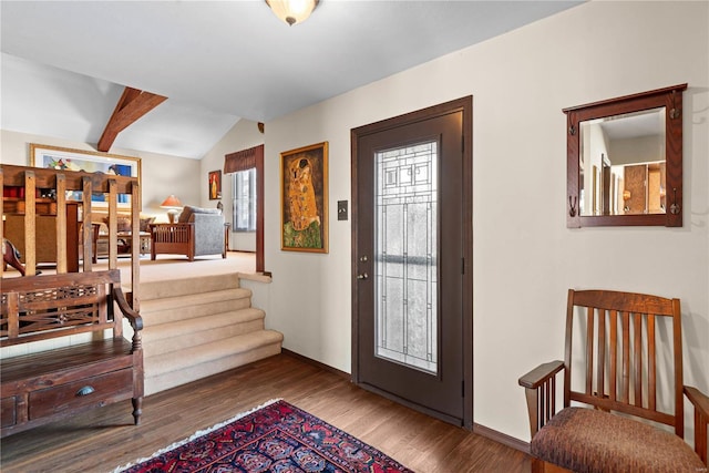 foyer entrance with hardwood / wood-style floors, a wealth of natural light, and vaulted ceiling with beams