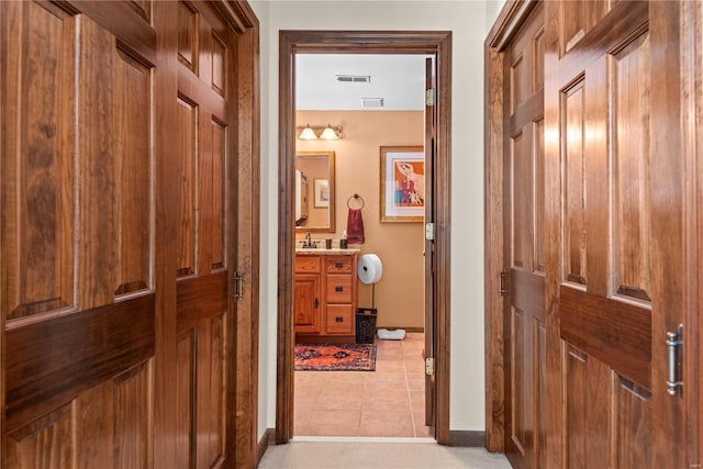 hallway featuring light tile patterned floors and sink