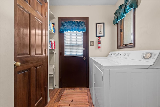 clothes washing area with dark hardwood / wood-style flooring and washing machine and clothes dryer