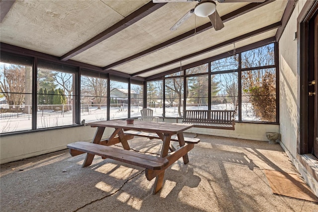 sunroom with ceiling fan and vaulted ceiling with beams