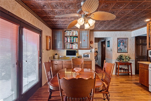 dining area with ceiling fan, crown molding, and light hardwood / wood-style flooring