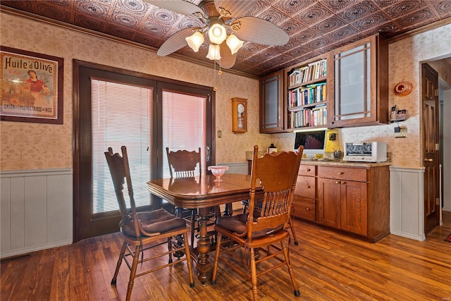 dining area featuring ceiling fan, ornamental molding, and hardwood / wood-style flooring