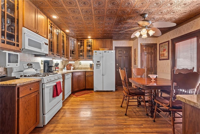 kitchen with light stone counters, white appliances, ceiling fan, and light wood-type flooring