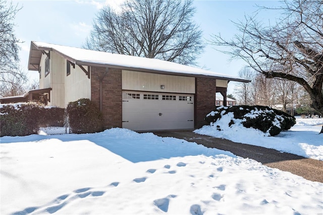 view of snowy exterior featuring a garage