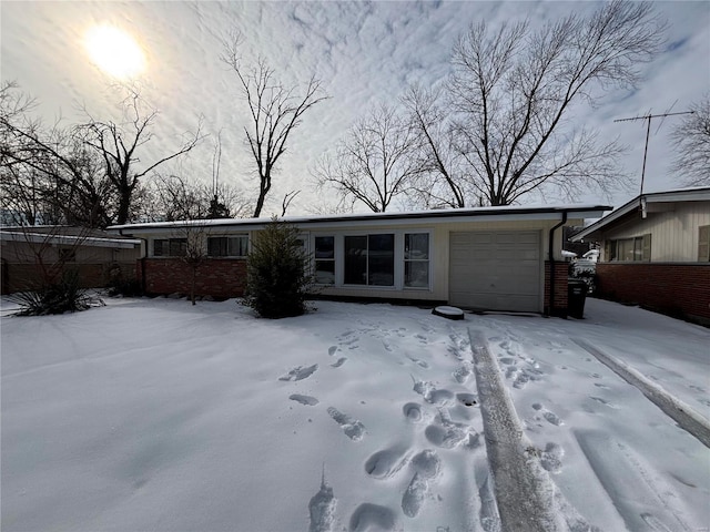 snow covered back of property with a garage