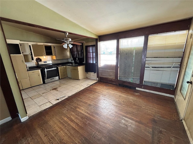 kitchen with ceiling fan, stainless steel gas stove, vaulted ceiling, light hardwood / wood-style flooring, and sink