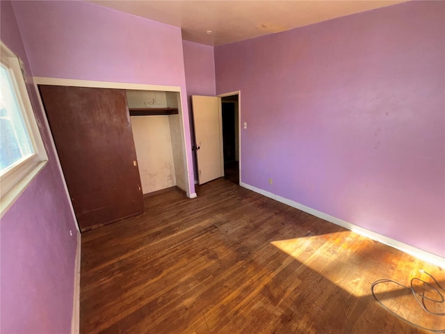 unfurnished bedroom with a closet and dark hardwood / wood-style floors