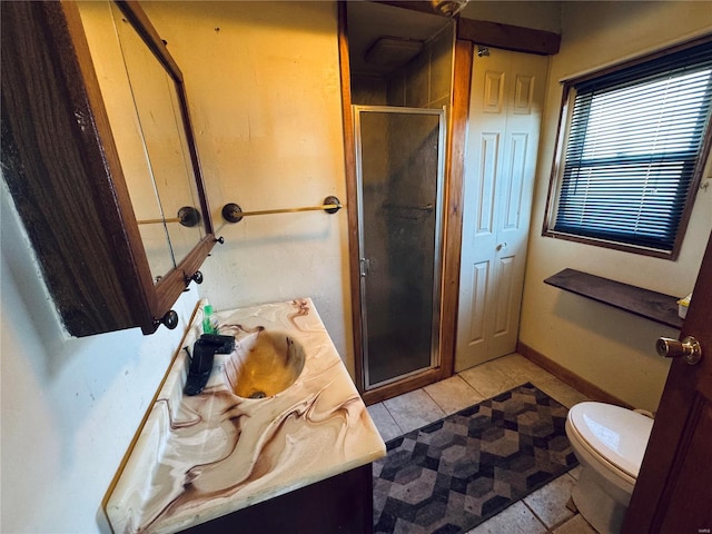 bathroom featuring toilet, vanity, a shower stall, tile patterned flooring, and baseboards