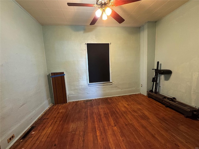 empty room featuring ceiling fan, visible vents, and hardwood / wood-style flooring