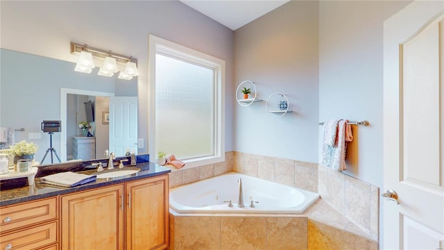 bathroom featuring vanity and a relaxing tiled tub