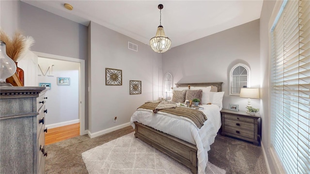 carpeted bedroom featuring vaulted ceiling and a chandelier