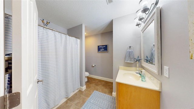 bathroom featuring tile patterned floors, a textured ceiling, toilet, and vanity