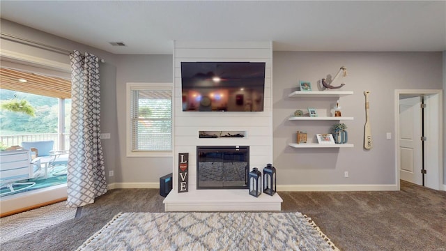 carpeted living room with a large fireplace