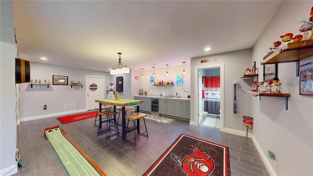 dining room featuring sink, an inviting chandelier, and wine cooler