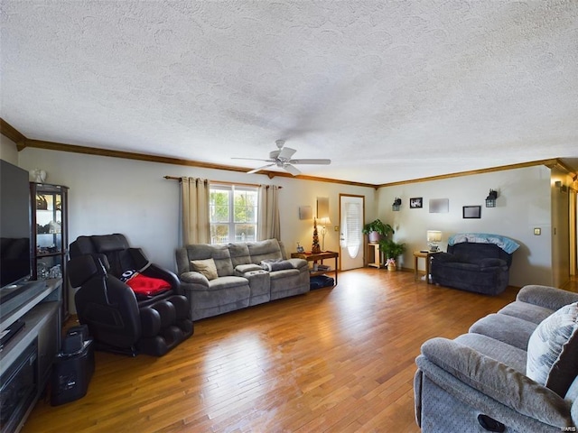 living room with wood-type flooring, ornamental molding, and a textured ceiling