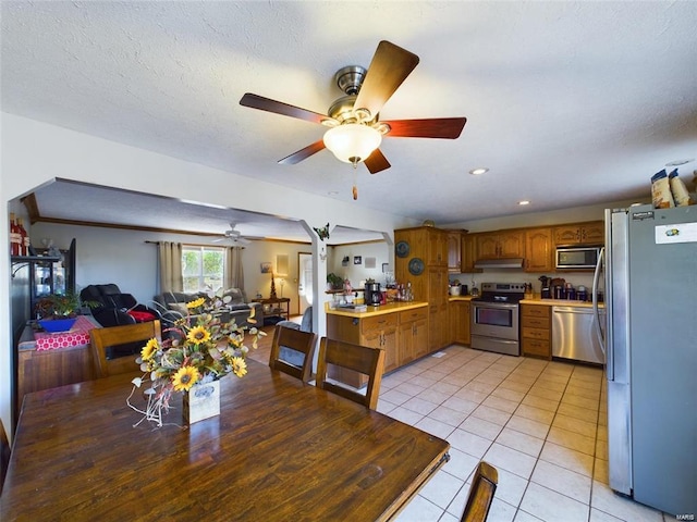 dining area featuring a textured ceiling, ceiling fan, and light tile patterned flooring